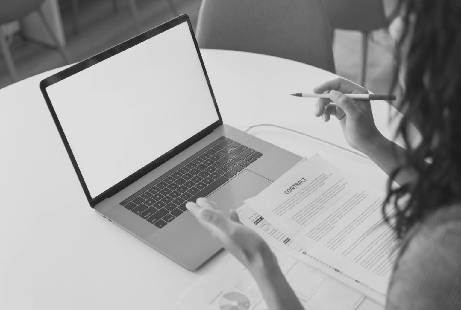 Person arbeitet an Finanzplanung mit Laptop und Notizen